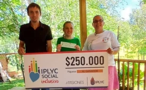 Yanina junto a su mamá y hermano muestran felices su cheque. IPLyC Inclusivo.