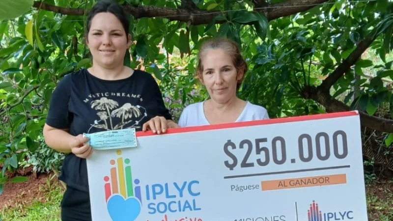 Marianela y su mamá muestran sonrientes su cheque del Inclusivo.