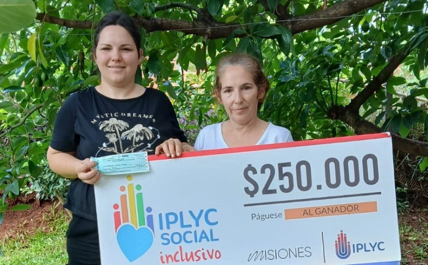 Marianela y su mamá muestran sonrientes su cheque del Inclusivo.