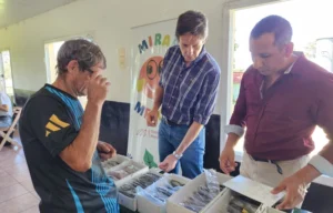 Héctor Decut y un vecino eligen un par de lentes que se llevará. Mirar Mejor - Mártires.