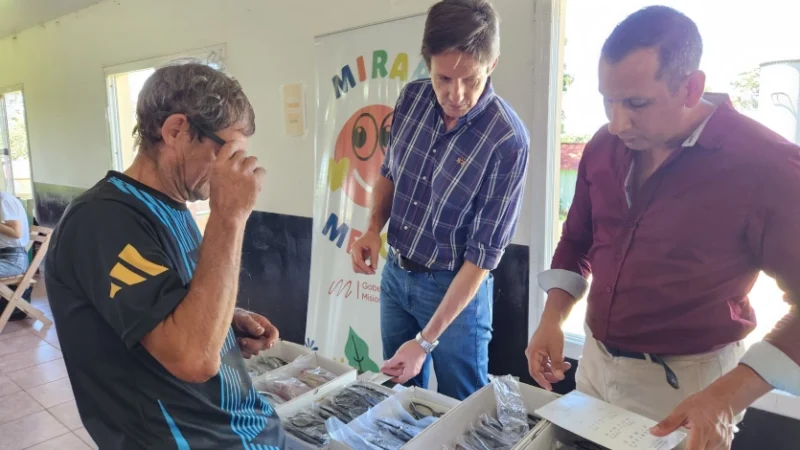 Héctor Decut y un vecino eligen un par de lentes que se llevará. Mirar Mejor - Mártires.