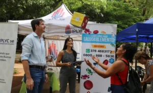 Héctor Decut y equipo de Juego Responsable juegan con dado gigante con una mujer en la plaza.