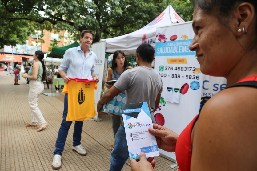 Mujer con un folleto sobre Juego Responsable. Difusión en el Día Internacional del Juego Responsable.