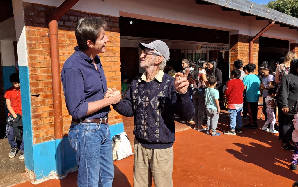 Héctor Decut se saluda con un vecino durante el operativo de Estamos con Vos en Aristóbulo Del Valle.