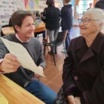 Abuela lee con sus nuevos lentes de Mirar Mejor junto a Héctor Decut en Itacaruaré.