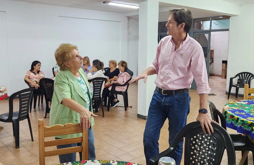 Héctor Decut charla con una abuela durante el bingo.