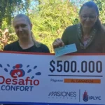 Liliana y su hija felices con su cheque. Usará el premio para operarse de cataratas.