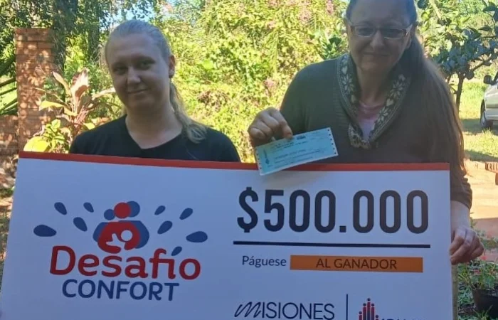 Liliana y su hija felices con su cheque. Usará el premio para operarse de cataratas.