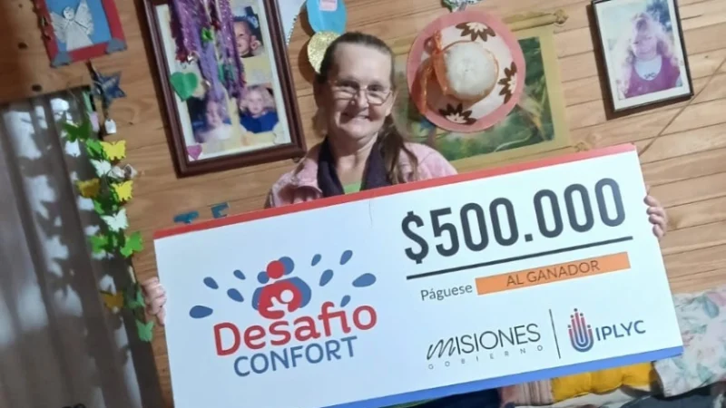 Luisa muestra sonriente el cheque de su premio de Desafío Confort.