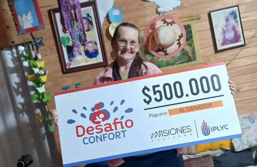 Luisa muestra sonriente el cheque de su premio de Desafío Confort.
