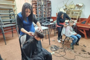 Dos peluqueras cortan el cabello a dos niños. Estamos con Vos - Oberá.