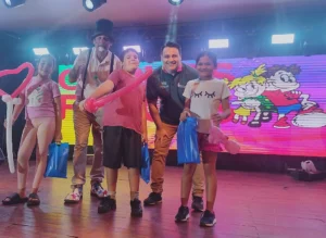 Poca Sopa y Marcelo Ledesma junto a tres niños felices con sus obsequios. Gurises Felices - IPLyC Social.