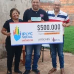 Ezequiel y sus padres felices con su cheque del Inclusivo. Con el premio hará un curso de cocina.