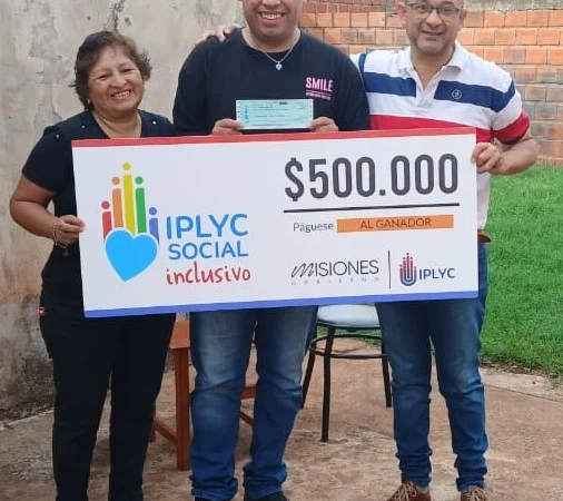 Ezequiel y sus padres felices con su cheque del Inclusivo. Con el premio hará un curso de cocina.