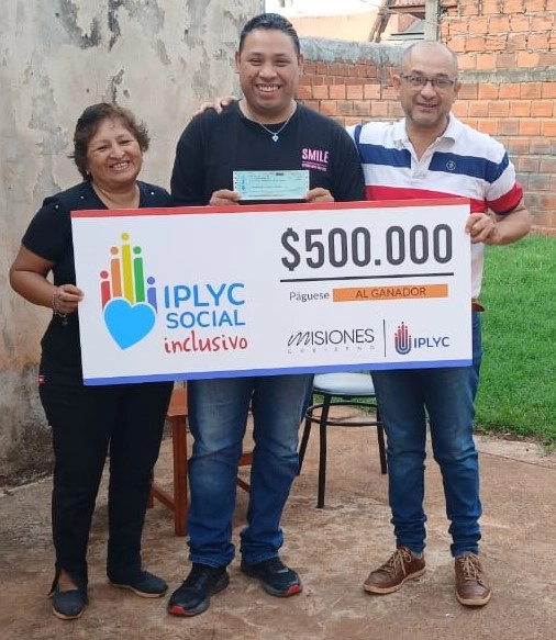 Ezequiel y sus padres felices con su cheque del Inclusivo. Con el premio hará un curso de cocina.