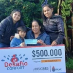 Ramona y sus hijos felices con su cheque. Usará el premio para los niños de su merendero.