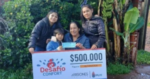 Ramona y sus hijos felices con su cheque. Usará el premio para los niños de su merendero.