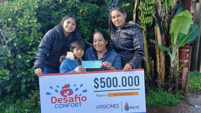 Ramona y sus hijos felices con su cheque. Usará el premio para los niños de su merendero.