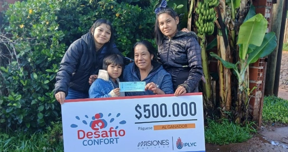 Ramona y sus hijos felices con su cheque. Usará el premio para los niños de su merendero.