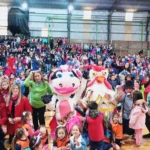 Los personajes de Gurises Felices junto a multitud de niños en La Fiesta de los Jardines en Alem.