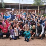 Equipo de Gurises Felices y multitud de niños de escuelas de Puerto Iguazú saludan felices a la cámara.