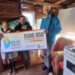 Mario y su mamá sonríen felices con su cheque del Inclusivo.