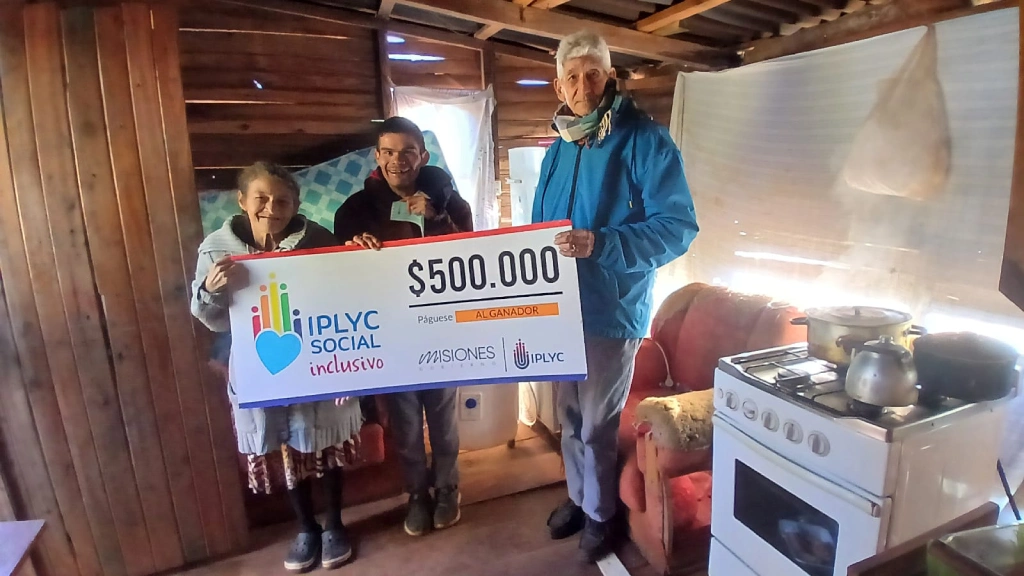 Mario y su mamá sonríen felices con su cheque del Inclusivo.
