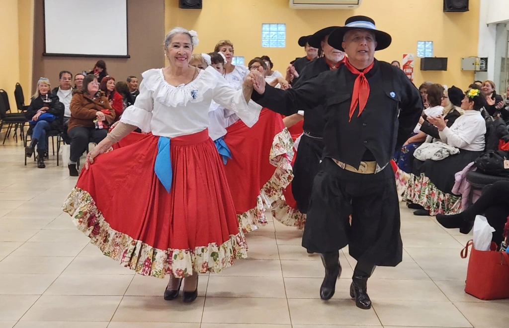 Grupo de danza folclórica de adultos mayores realiza una danza.