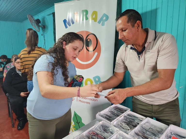 Una joven elije sus anteojos junto a un colaborador de Mirar Mejor.