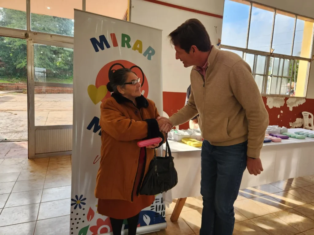 Héctor Decut estrecha la mano a una vecina que recibió sus nuevos lentes.