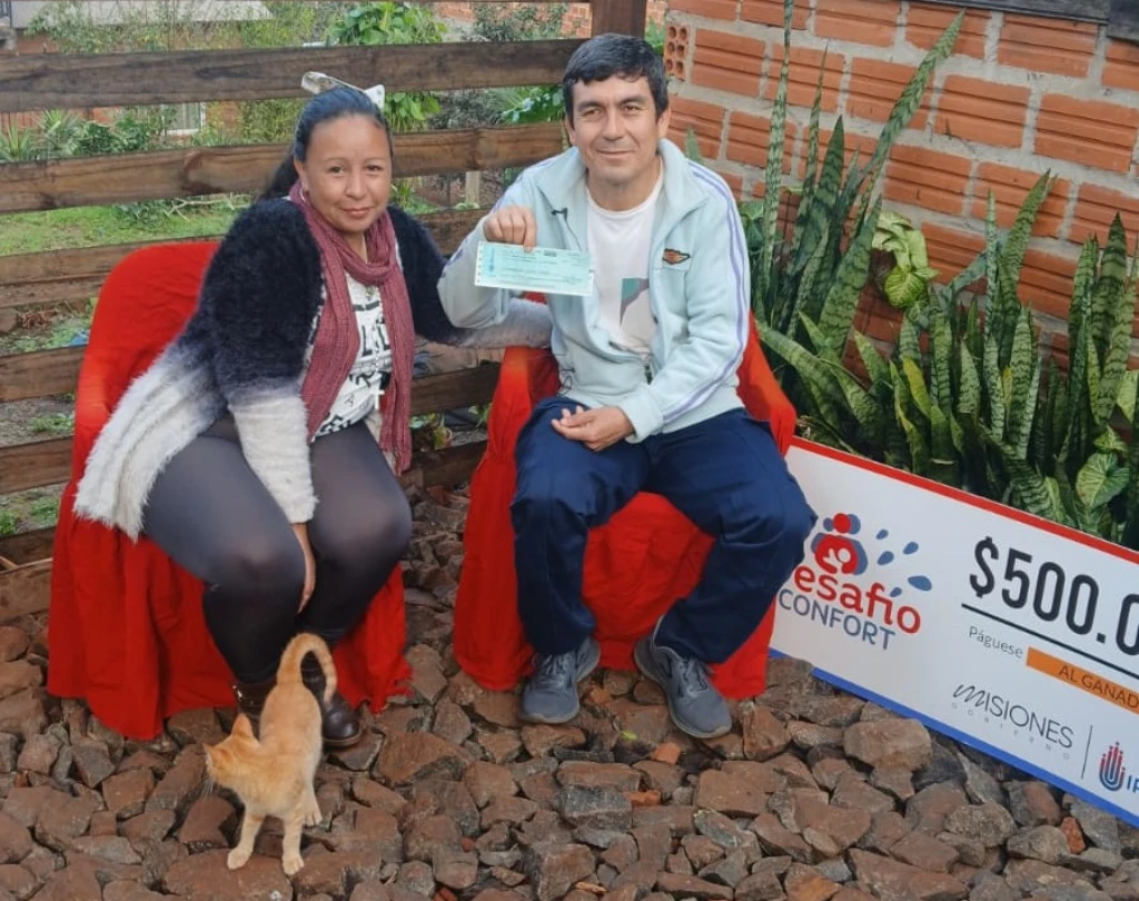 Héctor y Lorena sonríen con su cheque de Desafío Confort.