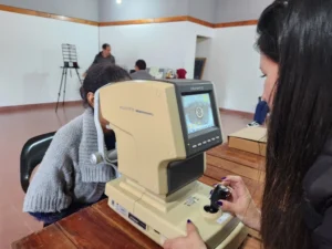 Una mujer joven recibe control de la vista con autorefractómetro. Mirar Mejor -Bonpland.
