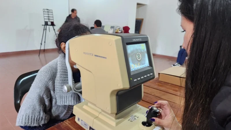 Una mujer joven recibe control de la vista con autorefractómetro. Mirar Mejor -Bonpland.