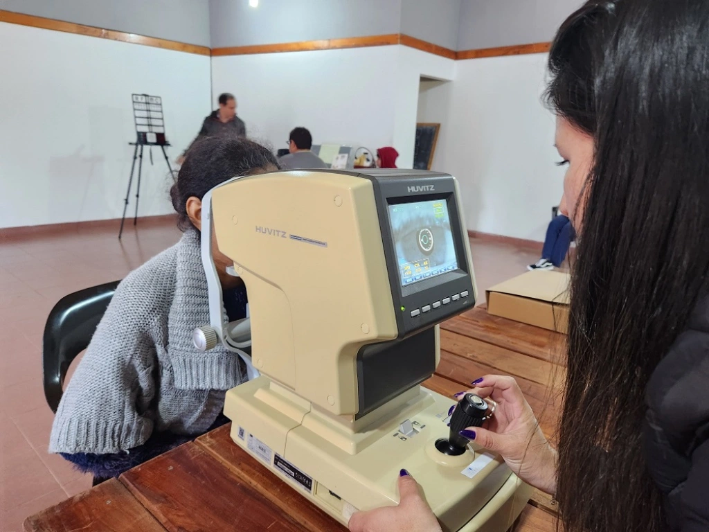 Una mujer joven recibe control de la vista con autorefractómetro. Mirar Mejor -Bonpland.