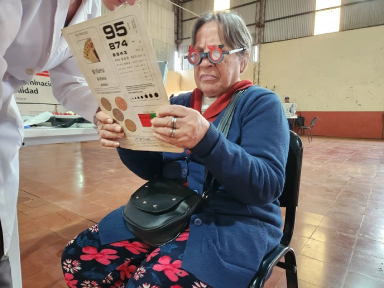 Señora mayor lee un texto de prueba con lentes graduados.
