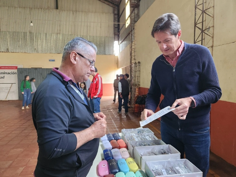 Héctor Decut ayuda a un vecino a elegir sus nuevos lentes.