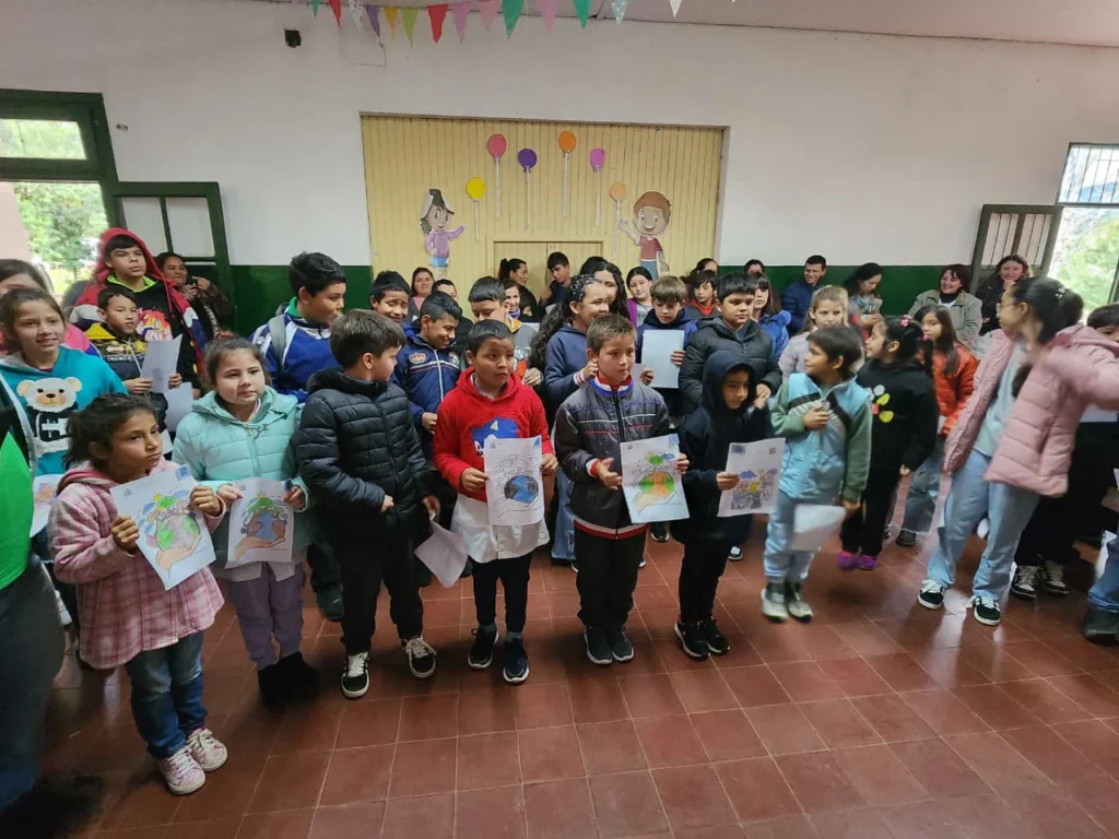 Los niños que disfrutaron del espacio para la infancia muestran los dibujos que realizaron.