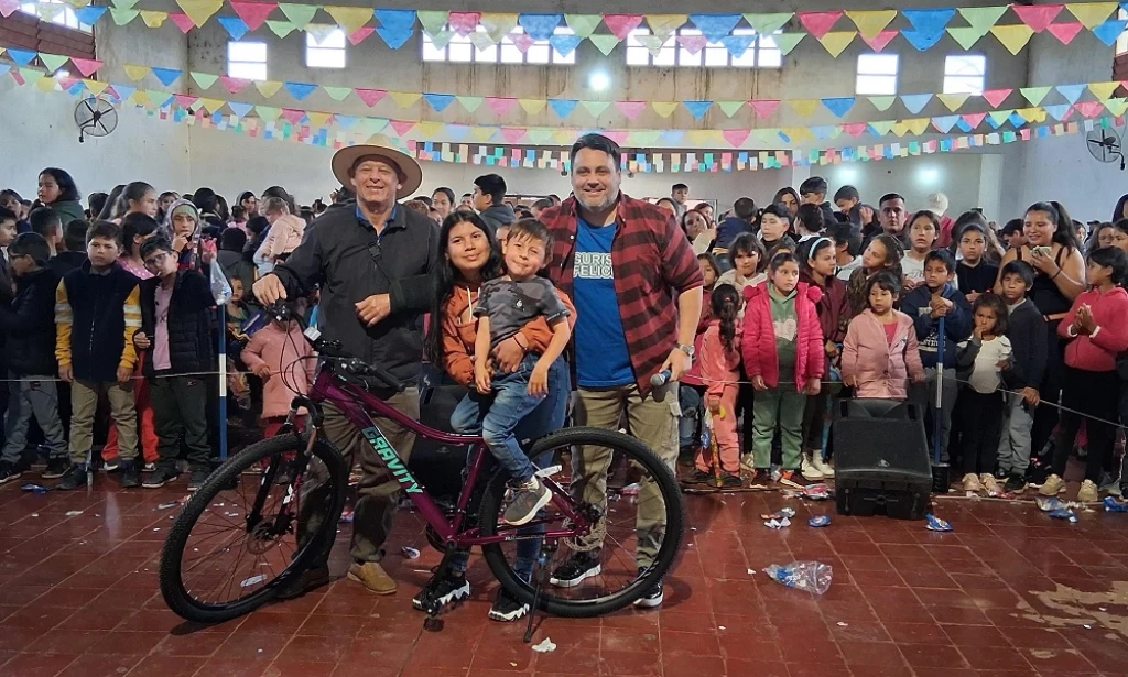 Un niño con su mamá se lleva una bicicleta de obsequio. Gurises Felices en Itacaroaré.