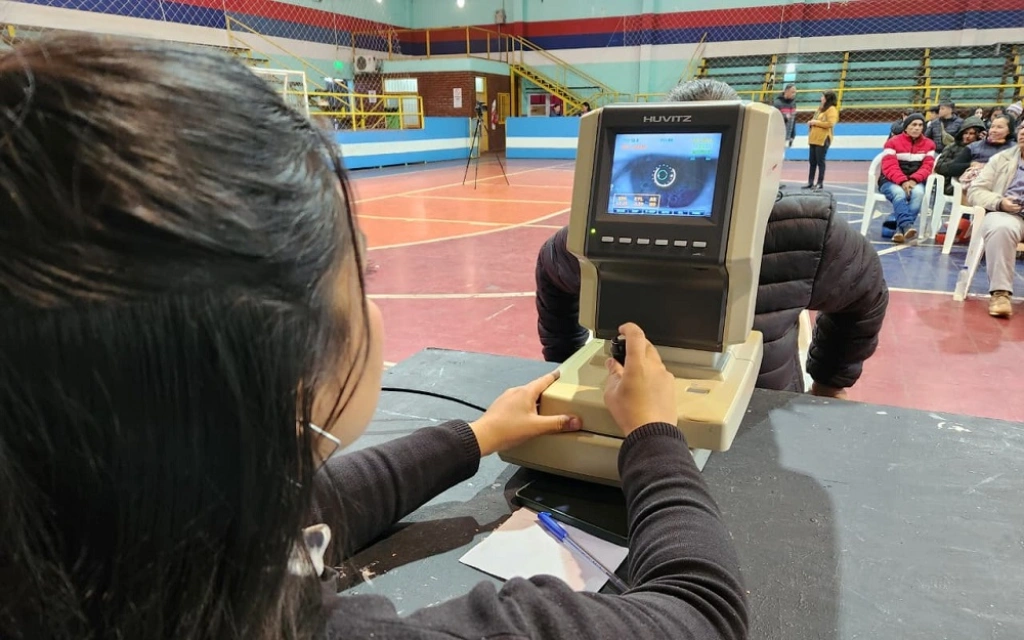 Oftalmóloga examina los ojos de una joven mediante un autorefractómetro.