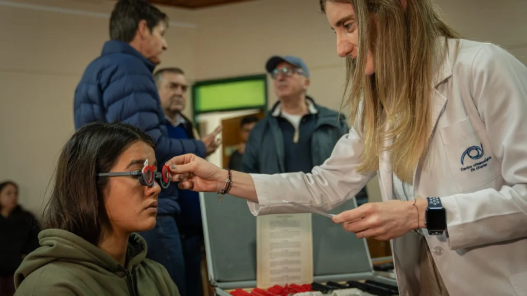 Oftalmóloga coloca lentes graduados para control a una joven durante el operativo en Azara.