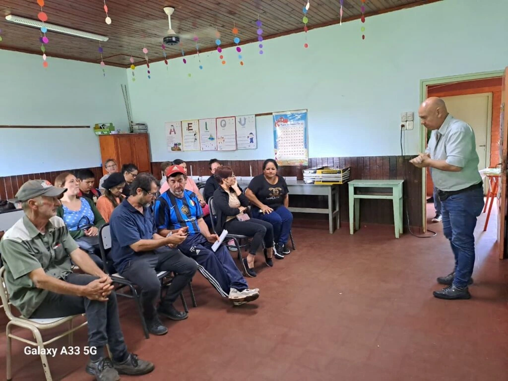 Colaborador del Programa atiende a vecinos que esperan sentados su turno.