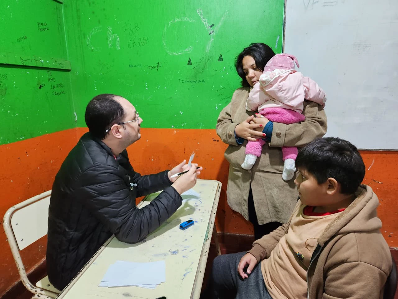 Colaborador del programa atiende a una mamá con sus dos hijos. Estamos con Vos - Santo Pipó.