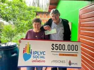 Jorge y su esposa felices con su cheque. Con el premio comprará ropa de trabajo y medicamentos.