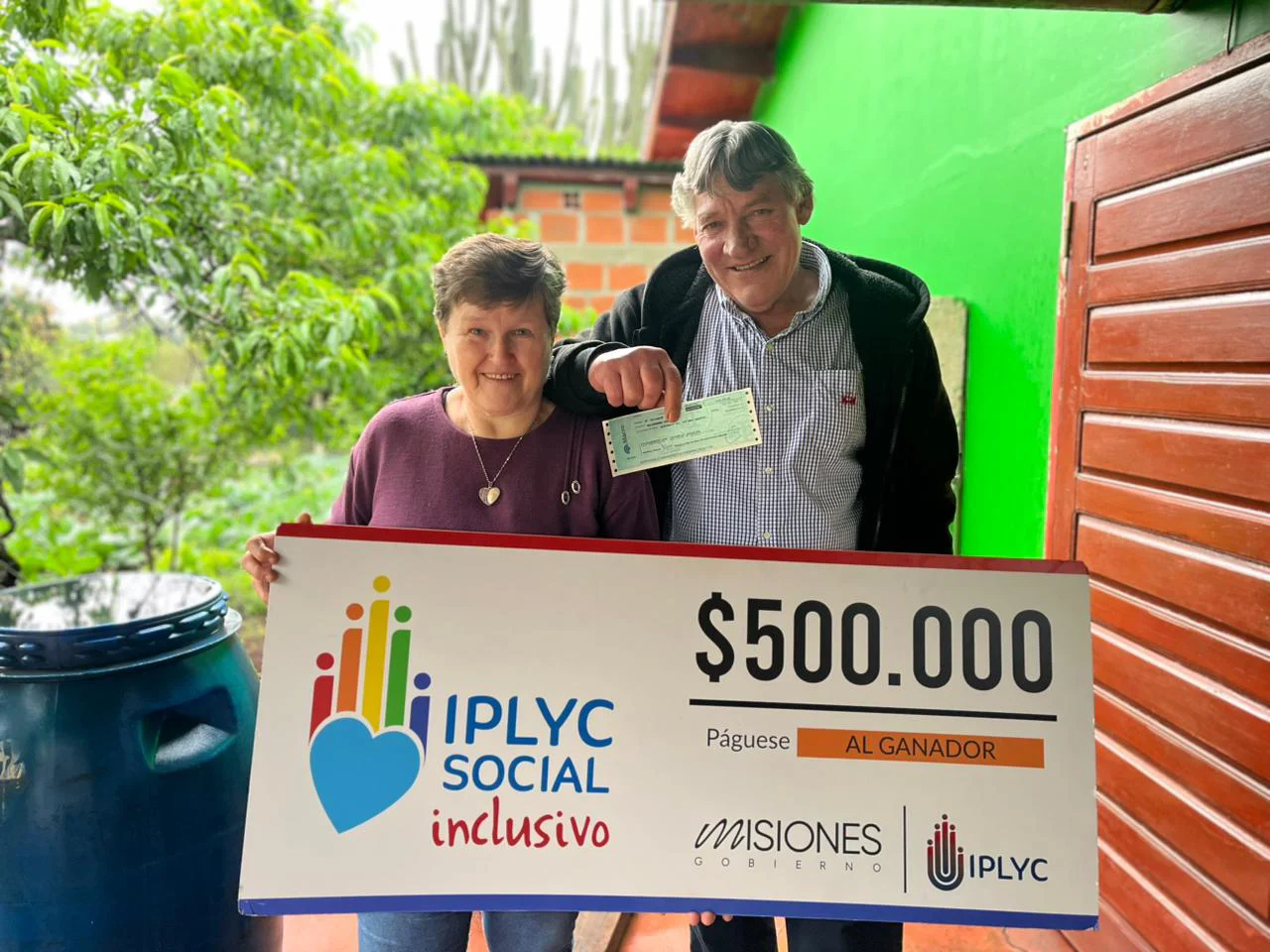 Jorge y su esposa felices con su cheque. Con el premio comprará ropa de trabajo y medicamentos.