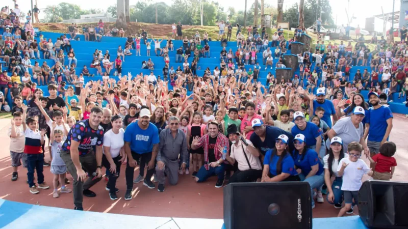 Equipo de Gurises Felices junto a multitud de niños en Bernardo De Irigoyen, saludan felices a la cámara.