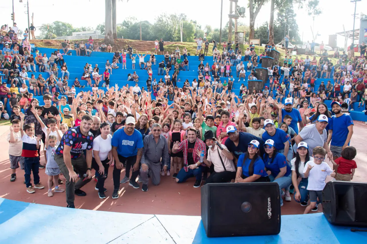 Equipo de Gurises Felices junto a multitud de niños en Bernardo De Irigoyen, saludan felices a la cámara.