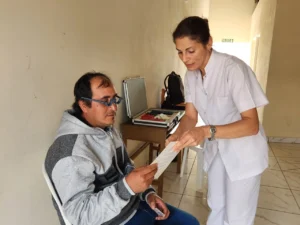 Oftalmóloga prueba lectura con lentes graduados a un vecino de San Antonio durante el operativo de Mirar Mejor.