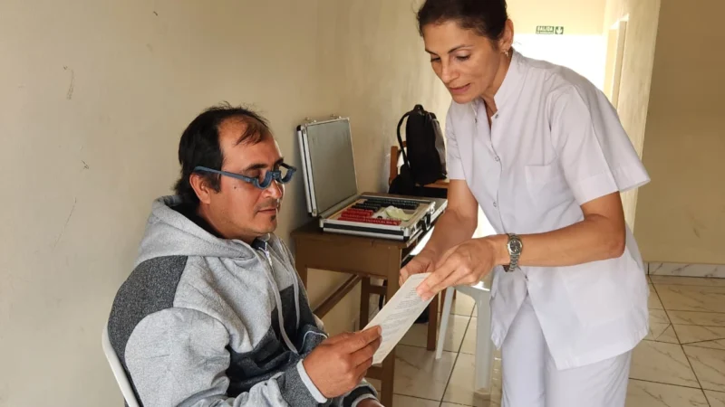 Oftalmóloga prueba lectura con lentes graduados a un vecino de San Antonio durante el operativo de Mirar Mejor.
