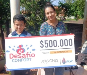 Graciela y su hijo felices con su cheque. Usarán el dinero para avanzar con la construcción de su casa.