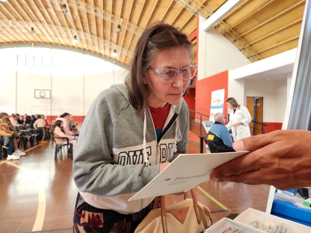 Señora lee un texto con sus nuevos lentes de Mirar Mejor, en 25 De Mayo.